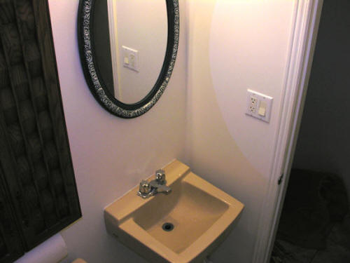 Removed wall paper trim and painted neutral Behr nude to blend with beige toilet and sink, replaced mirror, light and sink fixtures and matching accessories
